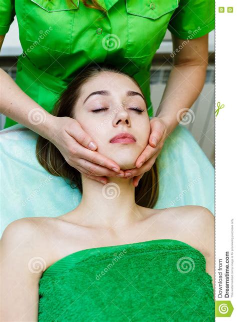 jeune fille caucasienne obtenant le massage de visage dans le salon de station thermale photo