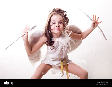Humorous Portrait Of A Cute Six Year Old Girl Dressed As A Cupid With White Wings Bow And Arrow