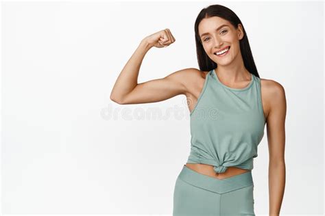 Smiling Brunette Fitness Girl Showing Muscles On Arm Flexing Biceps