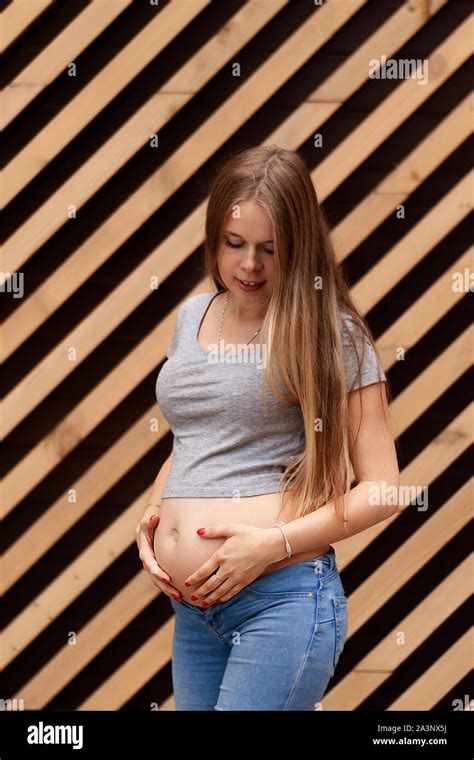 Young Beautiful And Happy Pregnant Girl On A Striped Background Second