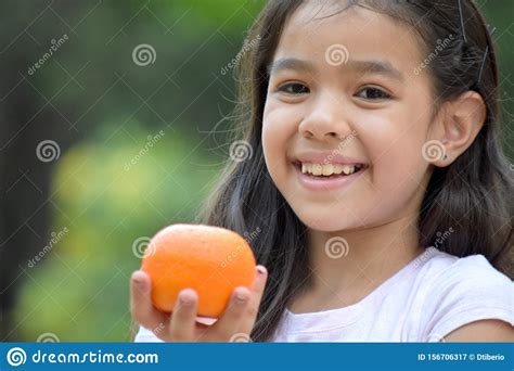 Cute Minority Female Smiling With An Orange Stock Image Image Of