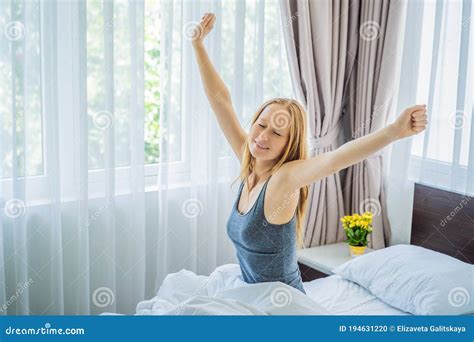 Young Woman Waking Up Happily After A Good Night Sleep Stock Photo