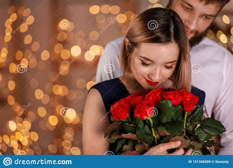 Loving Young Couple With Bouquet Of Beautiful Flowers On Romantic Date