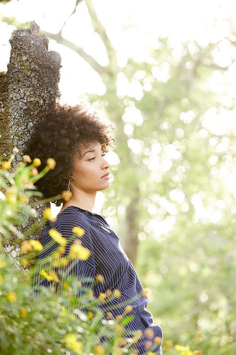 Portrait Of African American Woman Relaxing In Nature By Stocksy