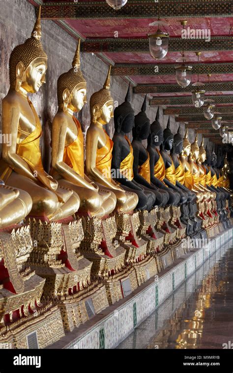 Wall With Row Of Buddha Statues In Meditation Posture On Decorated