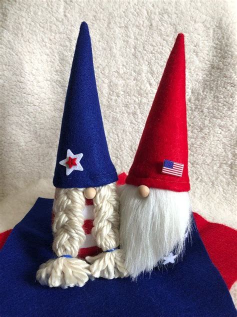 Two Gnomes Sitting Next To Each Other On Top Of A Blue And Red Blanket