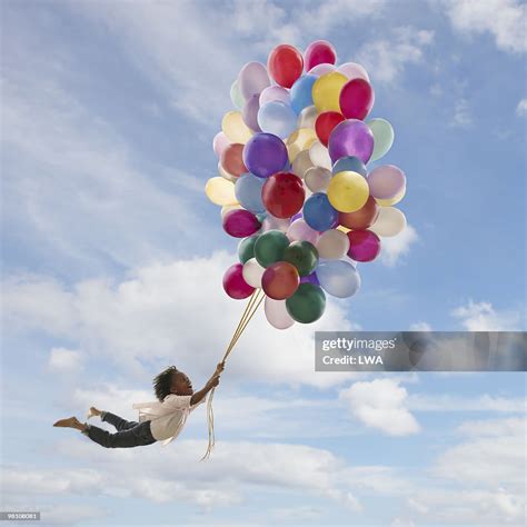 Girl Holding Onto Balloons Floating In The Air High Res Stock Photo