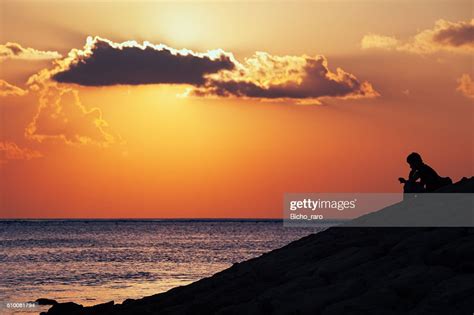 Black Silhouette Of Thinking Man Sitting Alone On Sea Beach High Res
