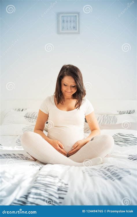 Beautiful Brunette Woman On A 7th Month Pregnancy In White Shirt And