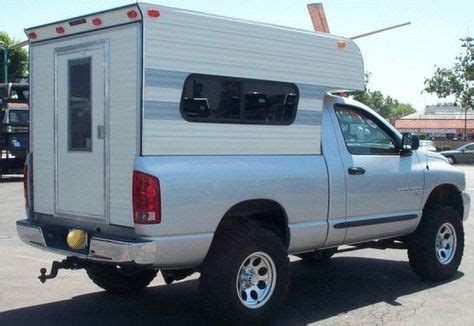 A Silver Truck With A Camper Attached To It S Back End In A Parking Lot