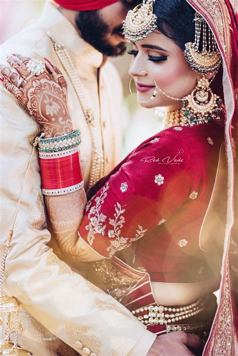 punjabi wedding with the bride in a stunning lehenga wedding couple poses punjabi wedding