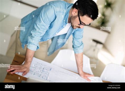 Portrait Of Adult Architect Working On Plans And Blueprints Stock Photo