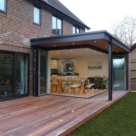 An Outdoor Living Area With Wooden Decking And Sliding Glass Doors