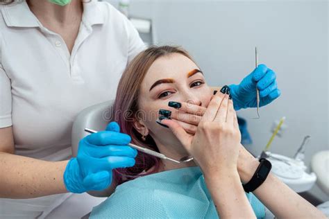 Female Patient Sits At Dentist And Closes Her Mouth From Female Dentist Because She Is Afraid