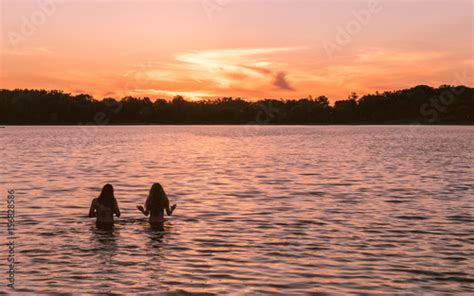 Girls Are Enjoying Sunset Scene On A Lake Stock Photo And Royalty