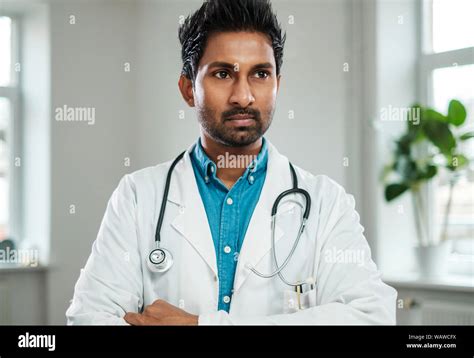 Indian Doctor With Stethoscope Around Neck In His Office Stock Photo
