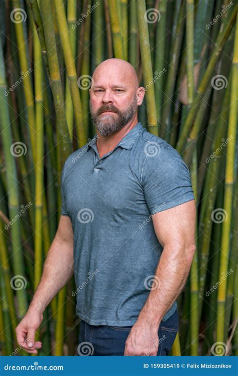 Handsome Macho Man Posing On A Bamboo Background Male Model Bald With