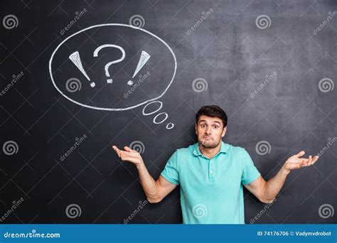 Confused Perplexed Young Man Shrugging Shoulders Over Chalkboard