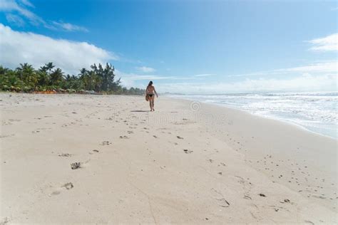 An Adult Woman In A Bikini Walking Under Strong Sunlight On Beach Stock