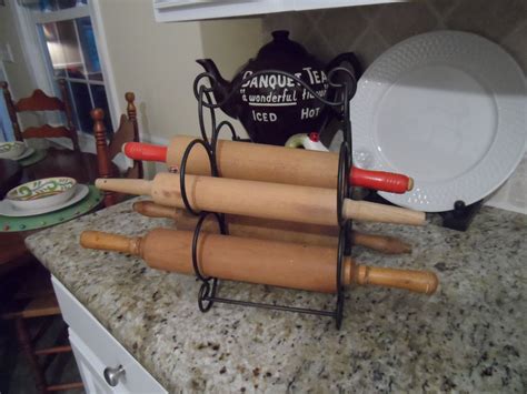 3 Generations Of Rolling Pins Displayed In A Wine Rack One From Each