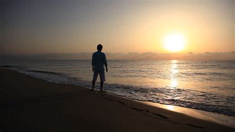 Man Walking On Beach At Sunset Stock Footage Video 2543447