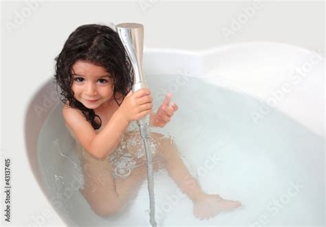Baby Girl Is Taking Shower In The Bathtub Stock Photo And Royalty