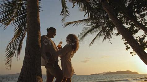 Loving Couple Near Palm Tree Kissing Hugging Relax And Drinki Stock