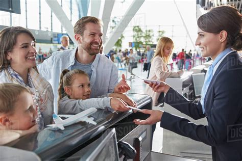 Customer service representative helping family checking in with tickets ...