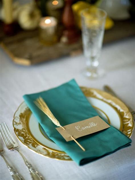 A Place Setting With Gold And Green Napkins