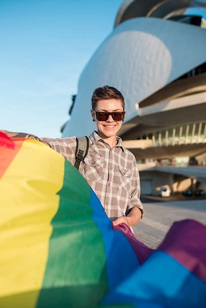 homosexual con bandera de arcoiris volando foto gratis