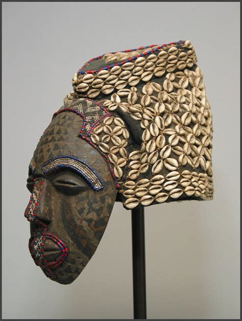 This kuba mask, known as mbwoom, is predominately made of carved wood with cowrie shell and bead embellishments. Kuba - Rand African Art