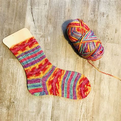 A Ball Of Yarn Next To A Pair Of Colorful Socks
