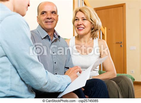 Mature Couple With Insurance Agent Mature Couple Discussing Details Of Private Insurance With
