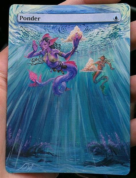 A Hand Holding Up A Card With Mermaids On It