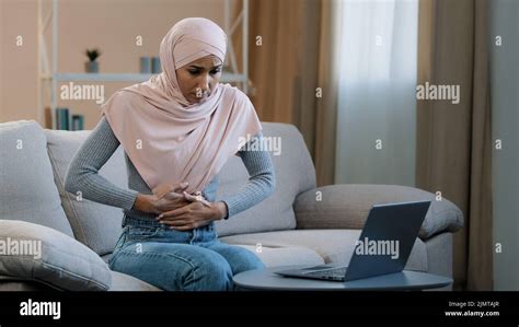 Young Islamic Arab Business Woman Muslim Girl In Hijab Sitting On Sofa