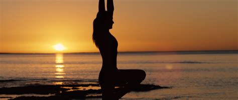 Woman Doing Yoga Near The Sea At Sunset Silhouette By Brad Day