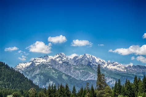 Green And White Snow Capped Mountain Under Blue Skies · Free Stock Photo