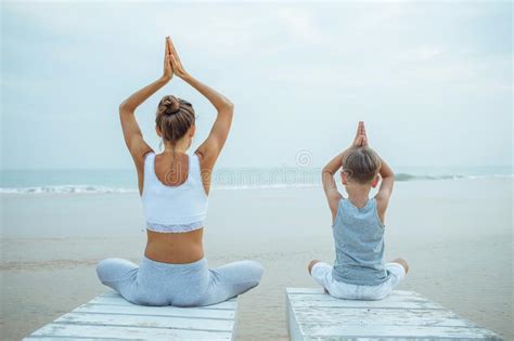 A Mother And A Son Are Doing Yoga Exercises At The Seashore Of Tropic Ocean Stock Image Image