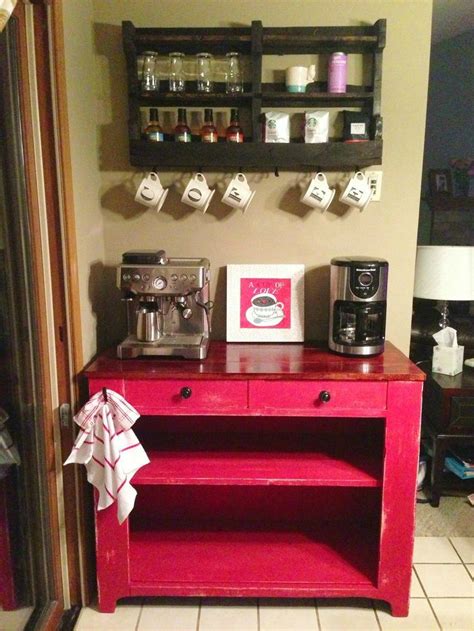 A Red Cabinet Sitting In The Corner Of A Room Next To A Wall Mounted Coffee Maker
