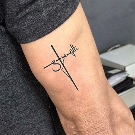 A Person With A Tattoo On Their Arm That Reads Strength And Has A Cross