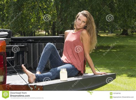 Beautiful Country Girl On Back Of Pick Up Truck Stock