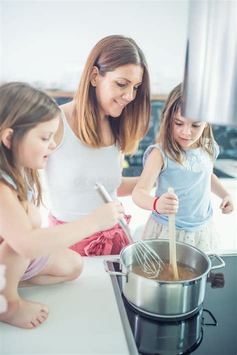 Mom With Two Young Twins Daughters In The Kitchen Cooking Spaghetti Stock Image Image Of