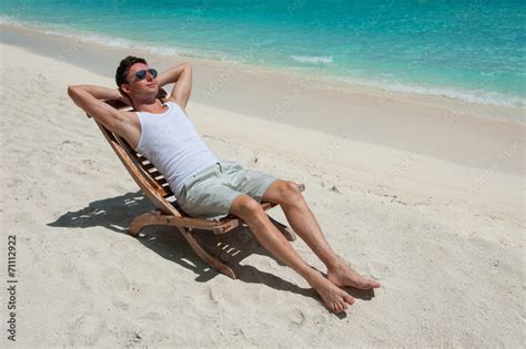 Man In Chair Sunbathing On The Beach Near The Sea Stock Photo Adobe Stock