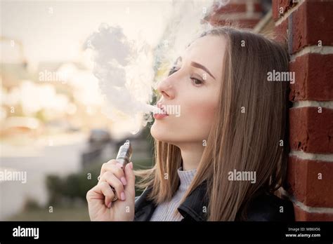 Young Woman Smoking Electronic Cigarette In The City Stock