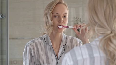 Woman Brushing Teeth In Front Of Mirror In Stock Footage SBV 311191274