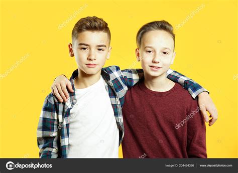 Child Boys Best Friends Hugging Looking Camera Yellow Background Two