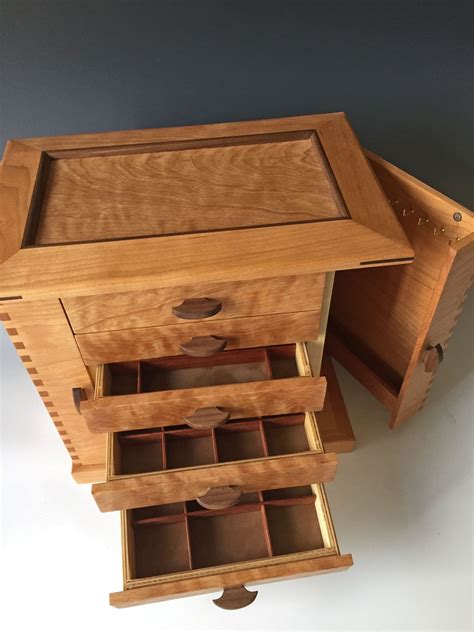 A Handmade Jewelry Box With Numerous Drawers Open To Show The Extensive