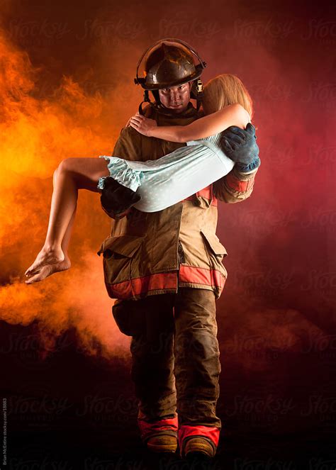 Fireman Carrying Woman From Buring Building By Brian Mcentire Stocksy