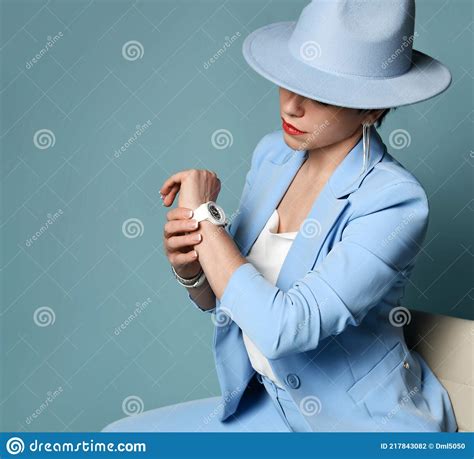 Attractive Short Haired Brunette Woman In Blue Business Smart Casual Suit Hat Sitting Looking