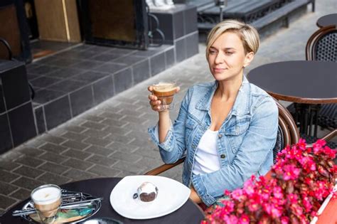 Eine Hübsche Frau Sitzt Mit Einer Tasse Kaffee An Einem Tisch In Einem Straßencafé Eine Blonde